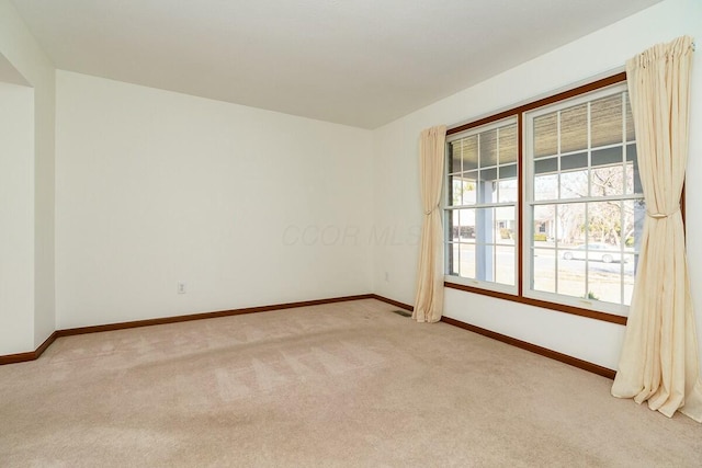 spare room with visible vents, baseboards, and carpet