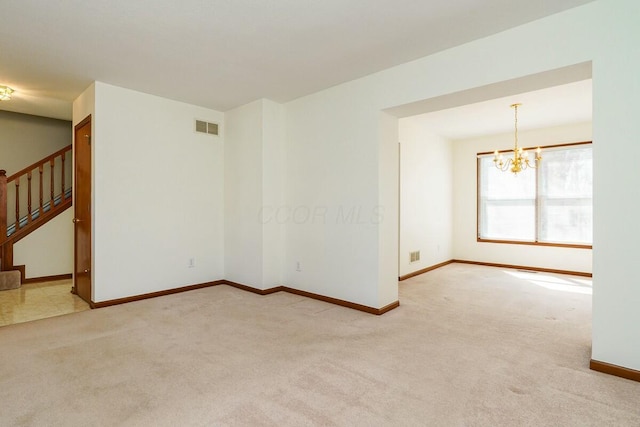 empty room featuring a notable chandelier, visible vents, carpet flooring, and stairs