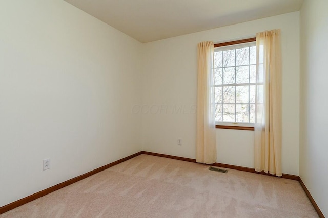 spare room with visible vents, carpet flooring, and a healthy amount of sunlight