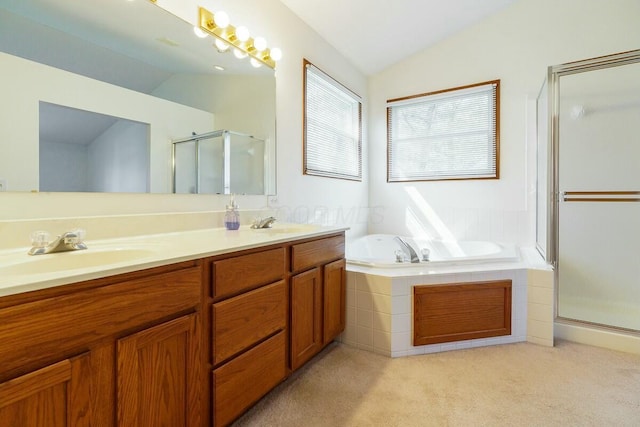 full bathroom featuring a garden tub, double vanity, lofted ceiling, a stall shower, and a sink