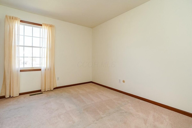 empty room with visible vents, baseboards, and carpet