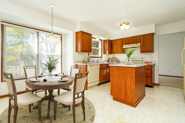 kitchen featuring a center island, white dishwasher, light countertops, range, and light floors