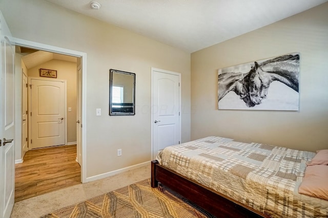 bedroom with light colored carpet and baseboards