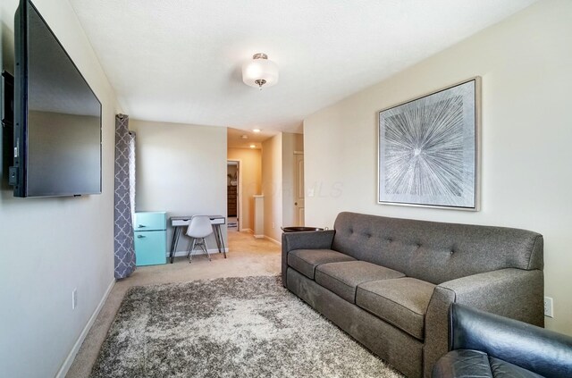 carpeted living area featuring baseboards