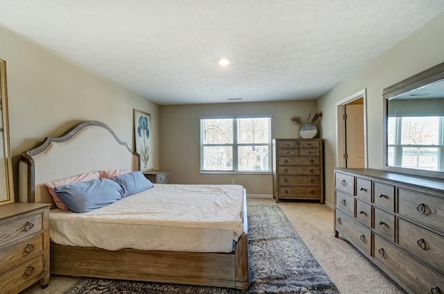 bedroom with baseboards, light carpet, and a textured ceiling