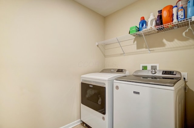 clothes washing area featuring laundry area, baseboards, and separate washer and dryer