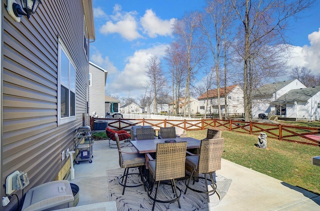view of patio with outdoor dining area, a fenced backyard, and a residential view