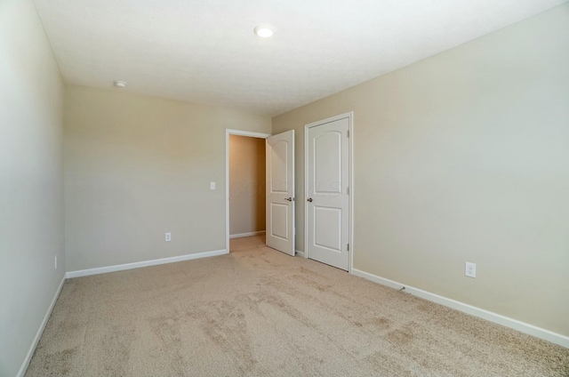 unfurnished room with carpet flooring and baseboards