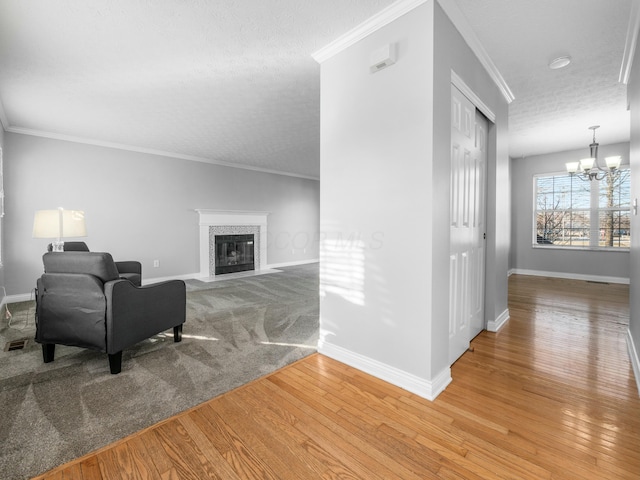 interior space featuring a premium fireplace, light wood finished floors, a chandelier, and ornamental molding