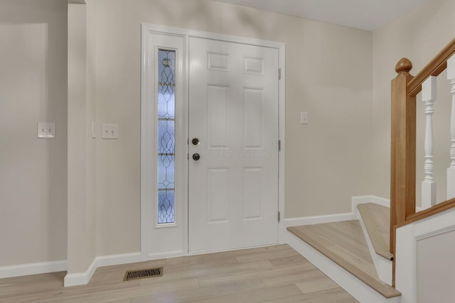 entryway featuring visible vents, light wood-type flooring, stairs, and baseboards