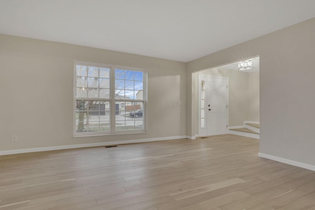 interior space featuring baseboards, visible vents, and light wood-type flooring