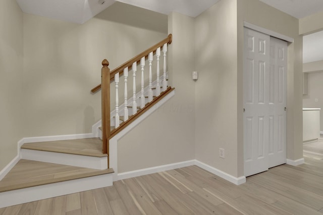 stairs with baseboards and wood finished floors