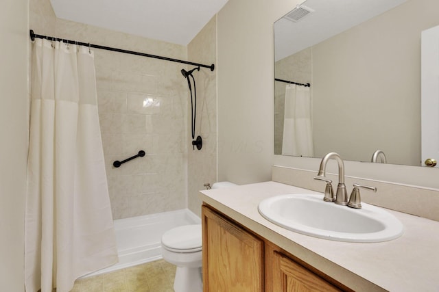 bathroom with vanity, toilet, visible vents, and tiled shower