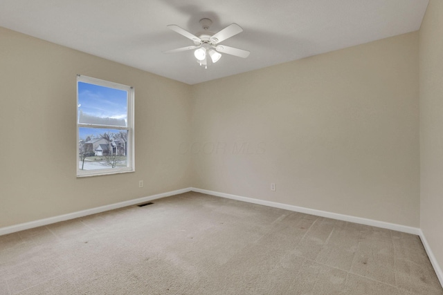 unfurnished room with visible vents, baseboards, light colored carpet, and a ceiling fan