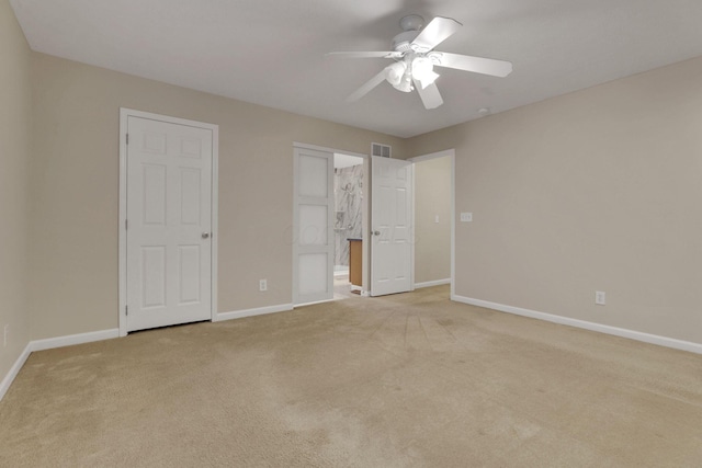 unfurnished bedroom with visible vents, light colored carpet, baseboards, and ceiling fan