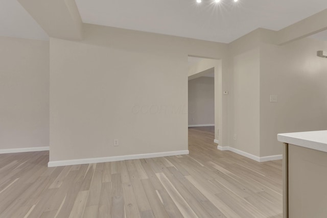 unfurnished room featuring baseboards and light wood finished floors