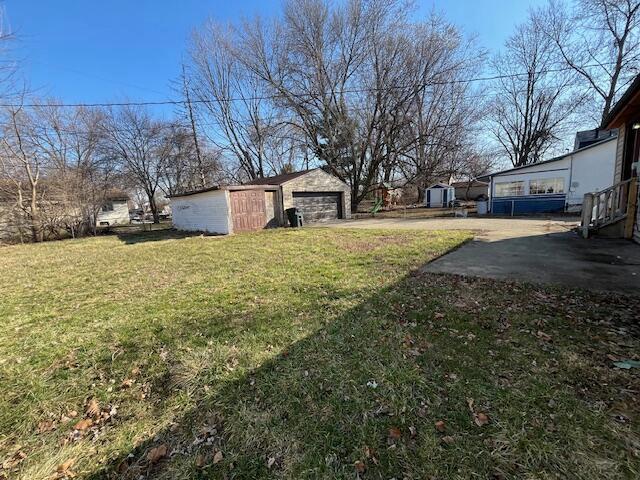 view of yard featuring a garage and an outdoor structure