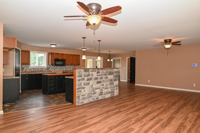 1025 Edison Ave, Marion, OH 43302 - kitchen with black microwave, a kitchen island, ceiling fan, wood finished floors, and dark cabinetry