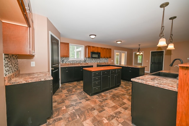 1025 Edison Ave, Marion, OH 43302 - kitchen featuring black microwave, a center island, decorative backsplash, and dark stone finish floors