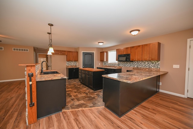 1025 Edison Ave, Marion, OH 43302 - kitchen featuring black microwave, tasteful backsplash, freestanding refrigerator, a center island, and brown cabinets