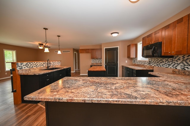 1025 Edison Ave, Marion, OH 43302 - kitchen with black microwave, decorative backsplash, wood finished floors, and a peninsula