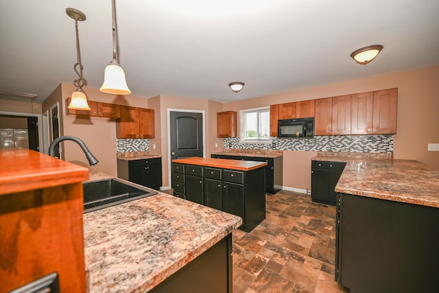 1025 Edison Ave, Marion, OH 43302 - kitchen with black microwave, tasteful backsplash, dark stone finish floors, decorative light fixtures, and brown cabinetry