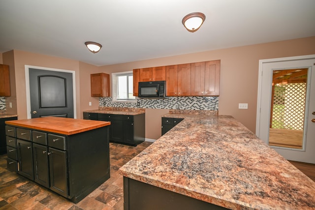 1025 Edison Ave, Marion, OH 43302 - kitchen with black microwave, wood counters, tasteful backsplash, and a peninsula