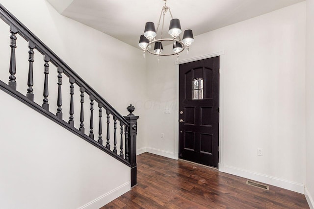 entryway featuring baseboards, visible vents, stairs, dark wood-type flooring, and a notable chandelier