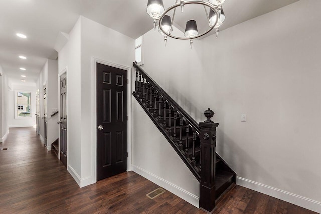 staircase with wood finished floors, visible vents, baseboards, an inviting chandelier, and recessed lighting