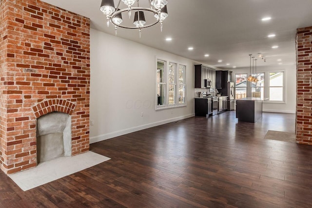 unfurnished living room featuring recessed lighting, baseboards, a chandelier, and dark wood-style flooring