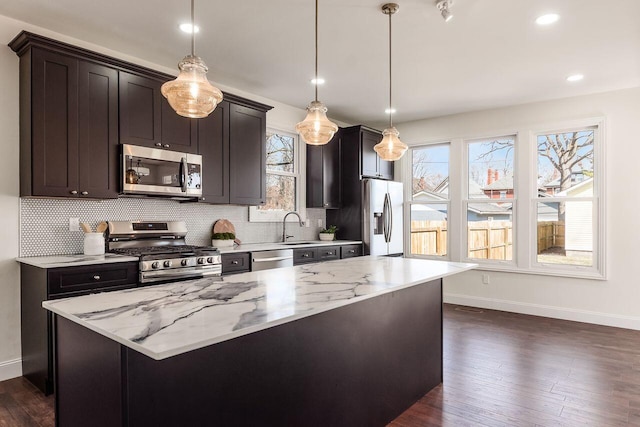 kitchen with light stone countertops, tasteful backsplash, dark wood-style flooring, and stainless steel appliances