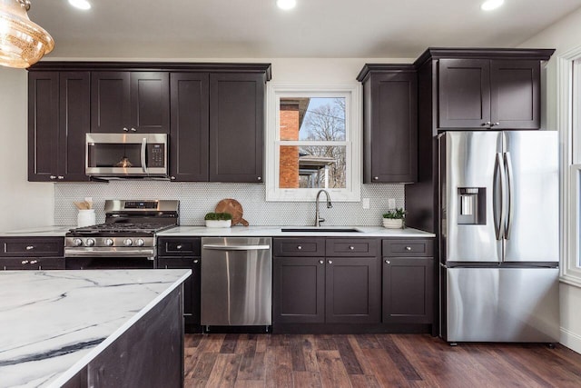 kitchen featuring a sink, stainless steel appliances, dark brown cabinetry, and dark wood finished floors