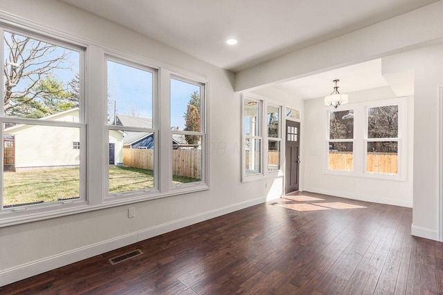 interior space with visible vents, baseboards, dark wood finished floors, recessed lighting, and an inviting chandelier