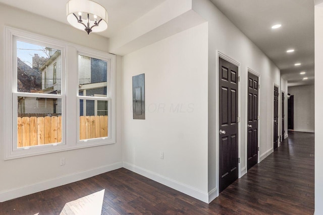 interior space featuring electric panel, recessed lighting, dark wood-type flooring, and baseboards