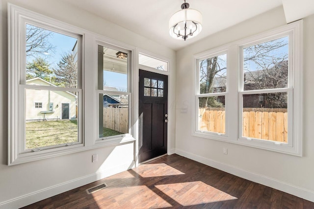 foyer featuring visible vents, baseboards, and dark wood-style flooring