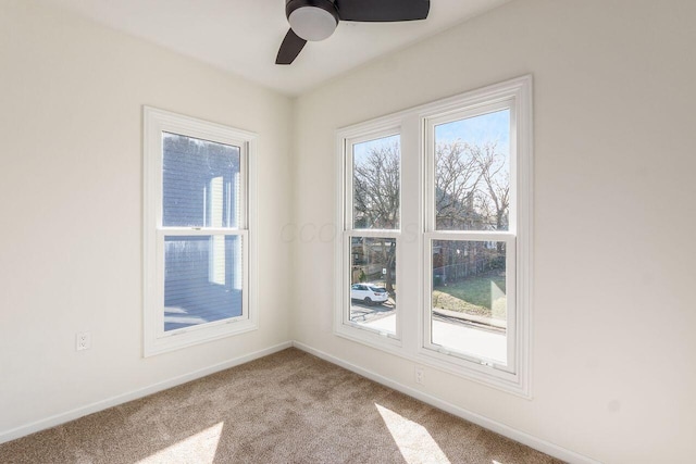 unfurnished room featuring carpet flooring, baseboards, and a ceiling fan