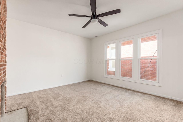 carpeted empty room featuring baseboards and ceiling fan