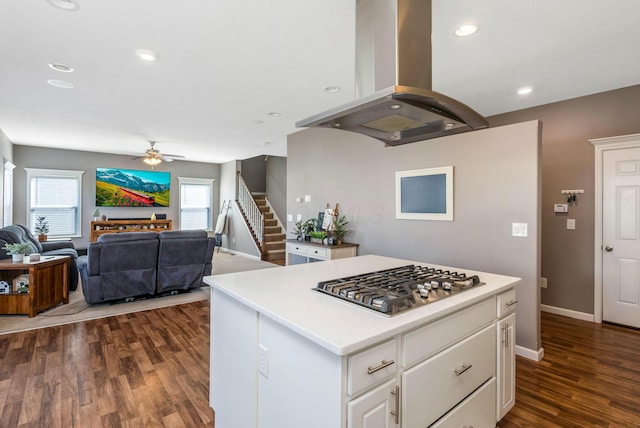 kitchen with stainless steel gas stovetop, plenty of natural light, dark wood finished floors, and island range hood