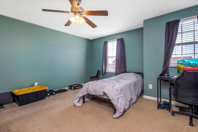 carpeted bedroom featuring baseboards and ceiling fan