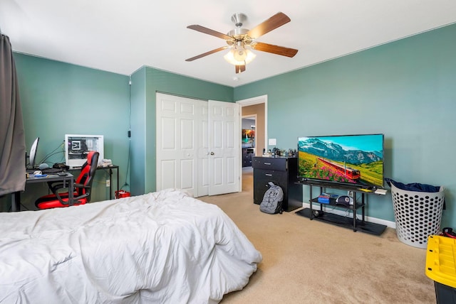 carpeted bedroom featuring a closet, baseboards, and ceiling fan