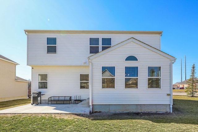 back of property with a patio area and a yard