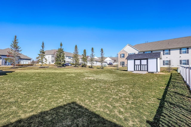 view of yard with a residential view, an outdoor structure, and fence