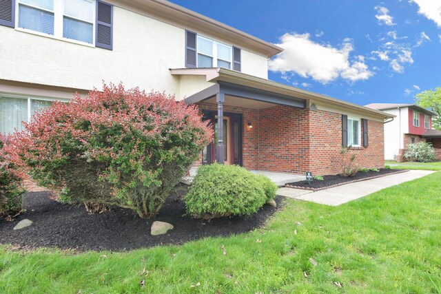 2639 Halleck Dr, Columbus, OH 43209 - view of front of property with a front yard, brick siding, and stucco siding