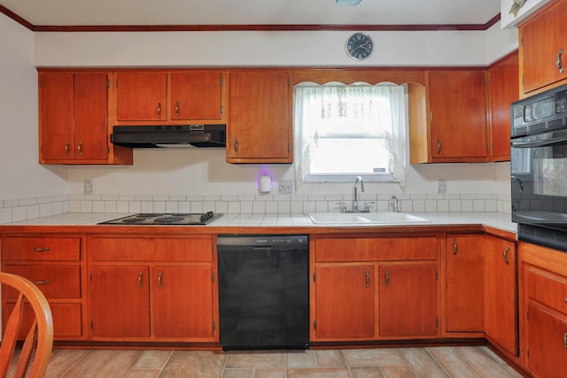 2639 Halleck Dr, Columbus, OH 43209 - kitchen with black appliances, under cabinet range hood, a sink, tile counters, and decorative backsplash