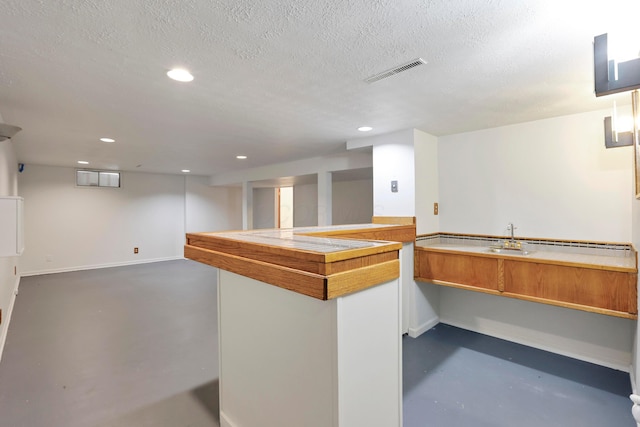 2639 Halleck Dr, Columbus, OH 43209 - bar area featuring finished concrete flooring, recessed lighting, a textured ceiling, baseboards, and a sink