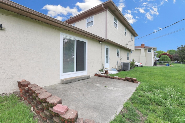 2639 Halleck Dr, Columbus, OH 43209 - rear view of house featuring stucco siding, a patio, a lawn, and central AC