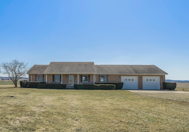 view of front facade with brick siding, concrete driveway, a front lawn, and a garage