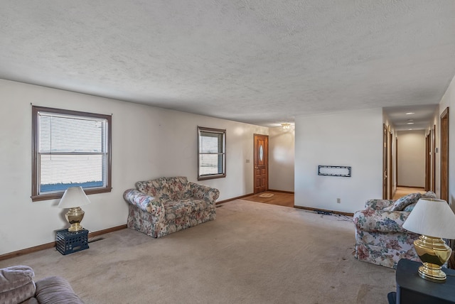 living area featuring baseboards, carpet floors, and a textured ceiling