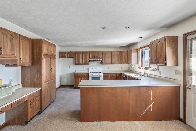 kitchen featuring under cabinet range hood, light countertops, white range with gas cooktop, brown cabinets, and a sink