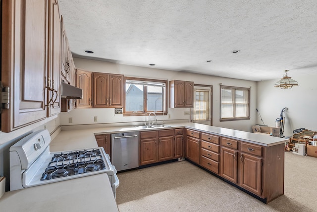 kitchen featuring a peninsula, white gas stove, a sink, dishwasher, and brown cabinets